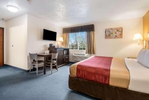 a hotel room with a bed and a table at Econo Lodge Corvallis Near University in Corvallis