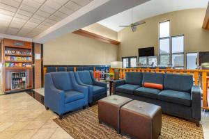 a waiting room with two blue couches and a table at Comfort Suites in Leesburg