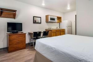 a bedroom with a bed and a kitchen with a microwave at WoodSpring Suites Abilene in Abilene