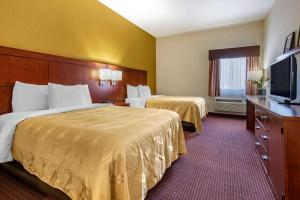 a hotel room with two beds and a flat screen tv at Quality Inn Zephyrhills-Dade City in Zephyrhills