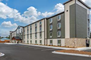 a large apartment building on a street with a parking lot at WoodSpring Suites Brunswick in Brunswick