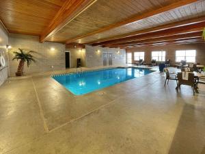 a large swimming pool in a building with a table and chairs at Comfort Inn & Suites Independence in Independence