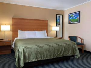 a hotel room with a bed and a chair and lamps at Quality Inn Ottawa near Starved Rock State Park in Ottawa +39 photos