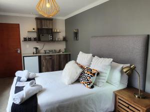 a bedroom with a large bed with white sheets and pillows at Sleep@84 in Dullstroom