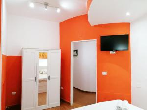 una camera da letto con parete arancione e specchio di Garden House Pompei Vesuvio a Trecase