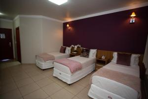 a hotel room with two beds and a black wall at Havana Express Uberaba in Uberaba