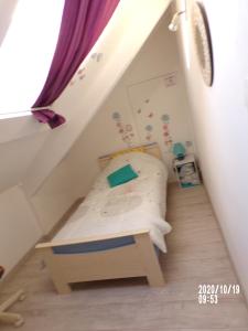 Dormitorio pequeño con cama en el ático en gite colorado, en Renac
