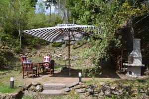 a table and chairs under an umbrella in a garden at Ferienhaus Lütsche in Frankenhain