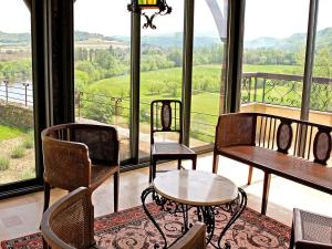 a room with chairs and tables and a large window at La Maison des Sarrasins in Beynac-et-Cazenac