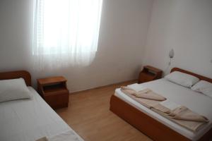 una camera con due letti e una finestra di Guest House Katić a Trpanj (Trappano)