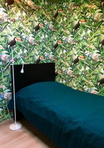 - une chambre avec un mur orné d'un papier peint à oiseaux dans l'établissement Paradiesje 3, à Leer