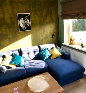 a blue couch with colorful pillows in a living room at Paradiesje 3 in Leer