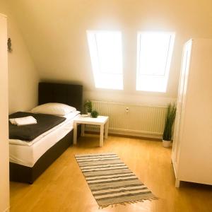 - une chambre avec un lit, 2 fenêtres et un tapis dans l'établissement SUNNYHOME Monteurwohnungen und Apartments nahe Regensburg, à Nittendorf