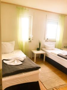 a small room with two beds and a window at SUNNYHOME Monteurwohnungen und Apartments nahe Regensburg in Nittendorf +1 photo