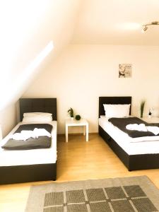 a bedroom with two beds and a table at SUNNYHOME Monteurwohnungen und Apartments nahe Regensburg in Nittendorf