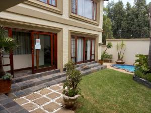a house with a yard with a swimming pool at Troas Boutique hotel in Vanderbijlpark