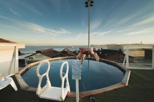 a man is standing on the edge of a swimming pool at Sunset Destination Hostel in Lisbon
