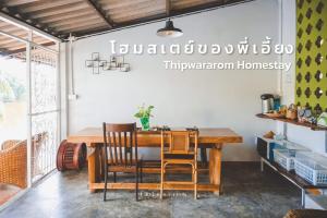 Takua PaThipwararom homestay的配有木桌椅的餐厅