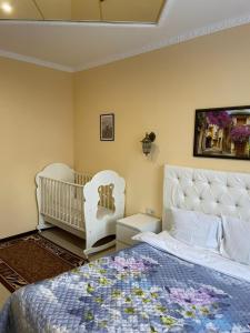 a bedroom with a white bed and a baby crib at Sheremetievo-Transit Hotel in Khimki