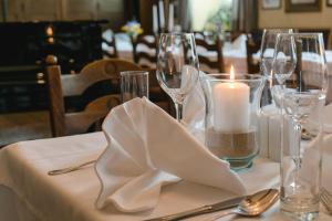 una mesa con una vela y copas de vino. en Hotel Garni - Gasthof Pillgrab, en Sankt Valentin