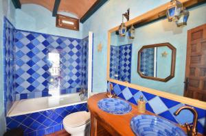 W wyłożonej niebieskimi kafelkami łazience znajduje się umywalka i toaleta. w obiekcie Carmen de la Bailaora w Grenadzie