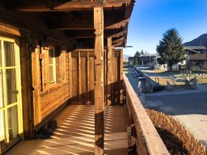 eine hölzerne Veranda eines Gebäudes auf einer Straße in der Unterkunft Alpin Residenzen Panoramabahn by Alpina-Holiday in Hollersbach im Pinzgau