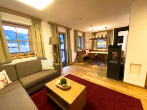 a living room with a couch and a table at Alpin Residenzen Panoramabahn by Alpina-Holiday in Hollersbach im Pinzgau