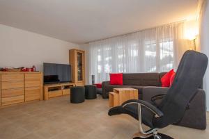 a living room with a couch and a television at Ferienwohnung Margeli in Adelboden