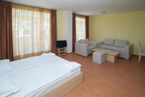- une chambre avec un lit, un canapé et une télévision dans l'établissement Aparthotel Anixi, à Obzor