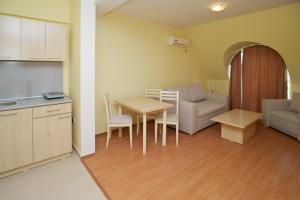 a kitchen and dining room with a table and a couch at Aparthotel Anixi in Obzor