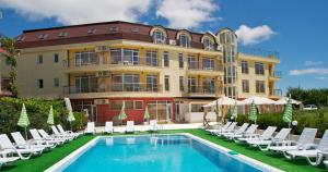 un hôtel avec une piscine, des chaises et un bâtiment dans l'établissement Aparthotel Anixi, à Obzor