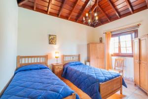 two beds in a bedroom with wooden ceilings at CASA VAN DE WALLE in Tijarafe +26 photos