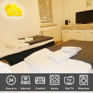 a hotel room with two beds and a flat screen tv at SUNNYHOME Monteurwohnungen und Apartments nahe Regensburg in Nittendorf