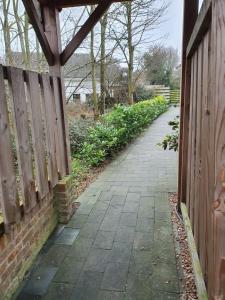 a walkway next to a wooden fence next to a sidewalk at Beachhouse Zeewinde in Zoutelande