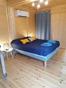 a bedroom with a bed in a wooden cabin at LE PRE DE L AIR in Saint-Michel-Mont-Mercure