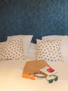 een bed met witte kussens en een blauwe muur bij Auberge Gardoise in Vallérargues