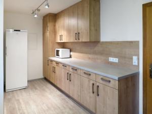kuchnia z drewnianymi szafkami i białą lodówką w obiekcie Holiday Home Eberharter by Interhome w Mayrhofen