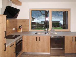 kuchnia ze zlewem i oknem w obiekcie Holiday Home Eberharter by Interhome w Mayrhofen
