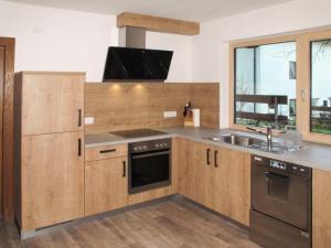 kuchnia z drewnianymi szafkami i zlewem w obiekcie Holiday Home Eberharter by Interhome w Mayrhofen