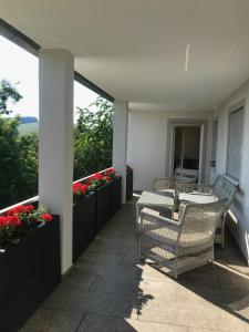 un balcone con tavolo, sedie e fiori di Apartment Schmuck a Bad Abbach