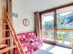 a living room with a couch and a large window at Studio Soyouz Vanguard-10 by Interhome in Le Corbier +22 photos