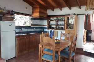 CASA EL VALLITO في Guarazoca: مطبخ مع طاولة خشبية وثلاجة بيضاء