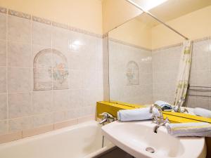 a bathroom with a sink and a bath tub at Studio Soyouz Vanguard-10 by Interhome in Le Corbier