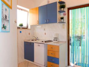 a kitchen with blue cabinets and a sink at Apartment Radmila - MLK142 by Interhome in Gostinjac
