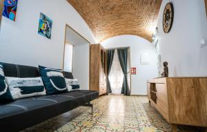 a living room with a black couch and a table at Art & SUITE Apartment Cáceres in Cáceres
