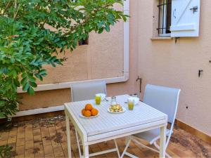 Biały stół i krzesła z pomarańczami w obiekcie Studio Les Vignes by Interhome w mieście Cavalaire-sur-Mer