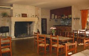 a dining room with a table and chairs and a fireplace at Hôtel Etang des Reynats in Chancelade