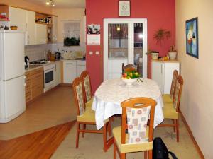 a kitchen with a table and chairs and a kitchen with red walls at Apartment Mira by Interhome in Mirce