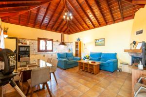 a living room with blue couches and a table at CASA VAN DE WALLE in Tijarafe