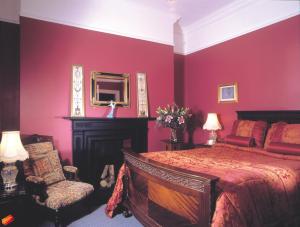 um quarto com uma cama, um espelho e uma cadeira em Ivyleigh House em Portlaoise